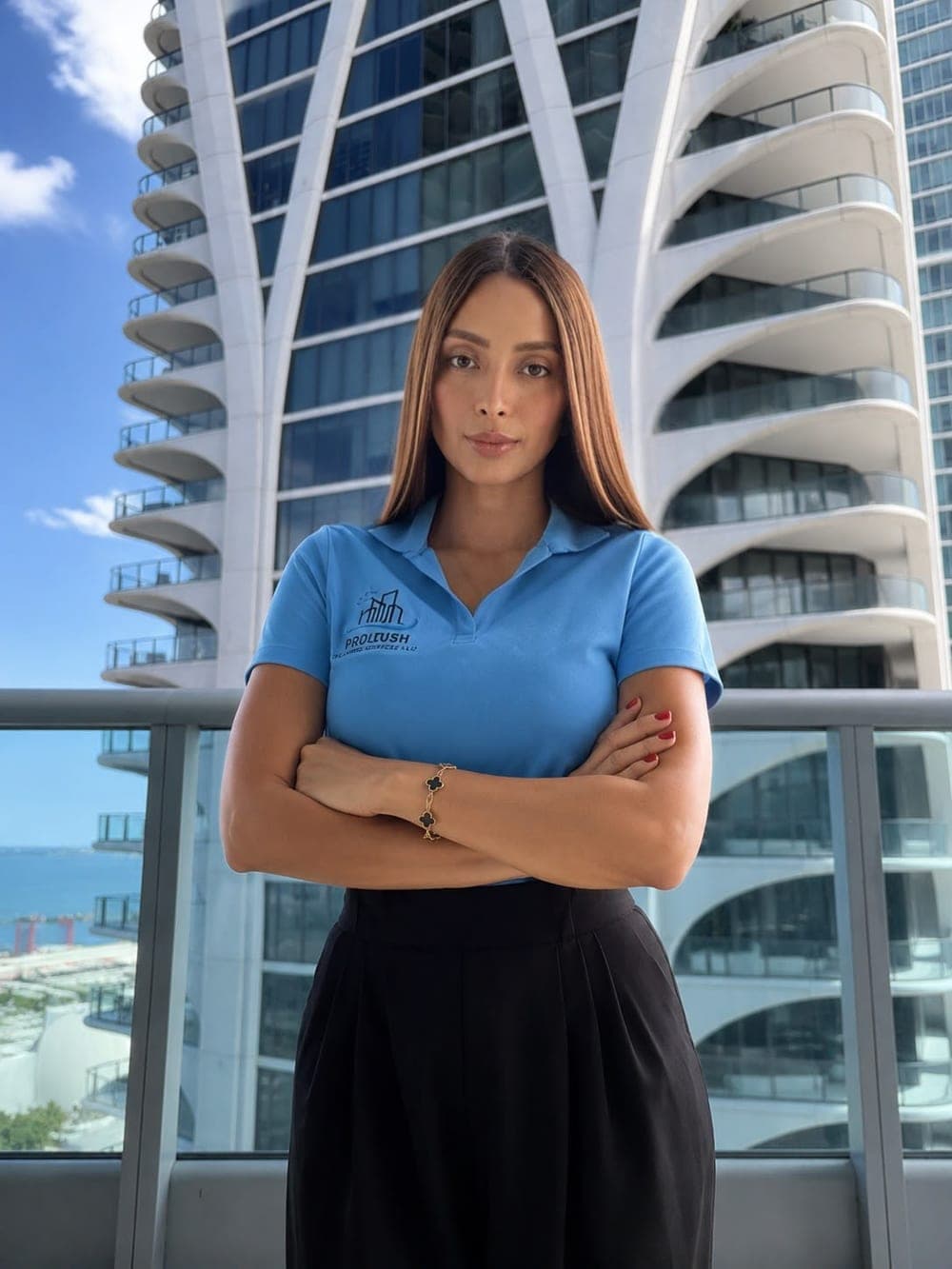 The founder of Prolush Cleaning on a Miami balcony, wearing the sky blue Prolush polo